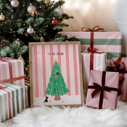 Framed Christmas-themed artwork with presents and a decorated tree in the background