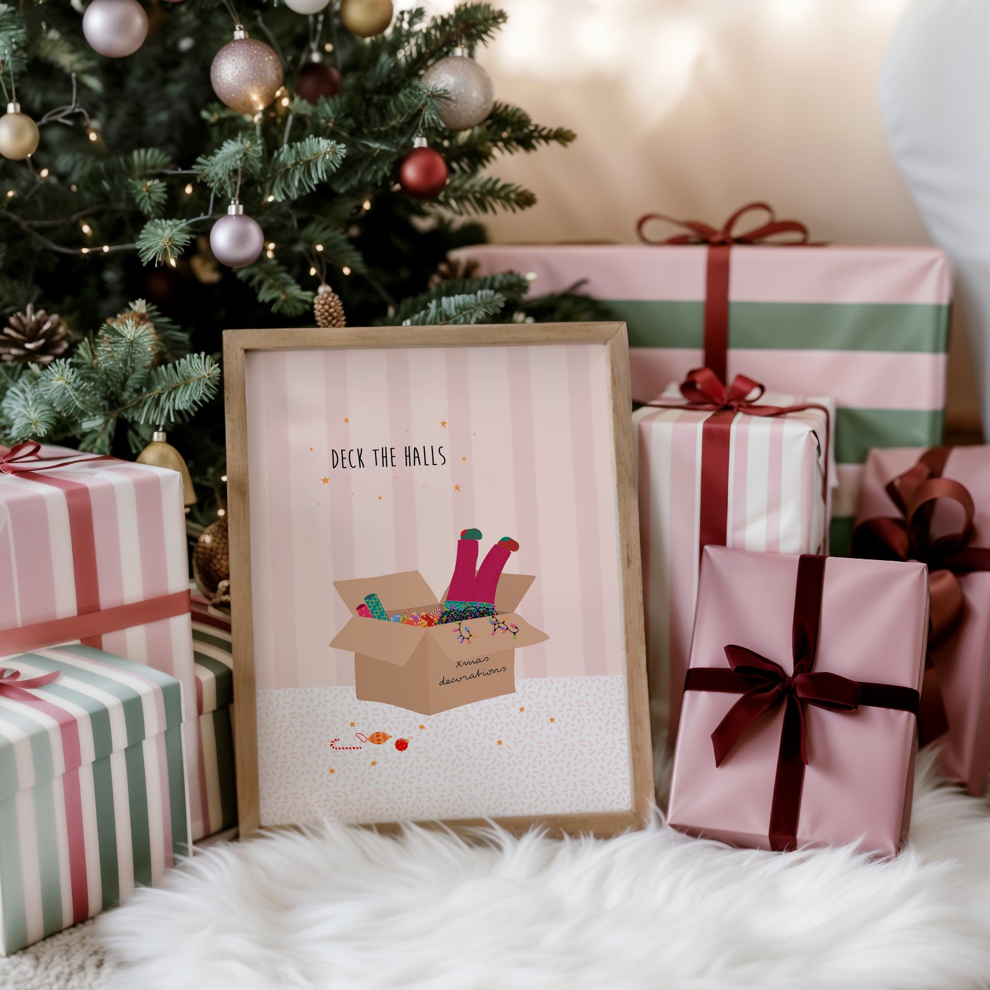 Framed Christmas-themed print with presents and a decorated tree in the background