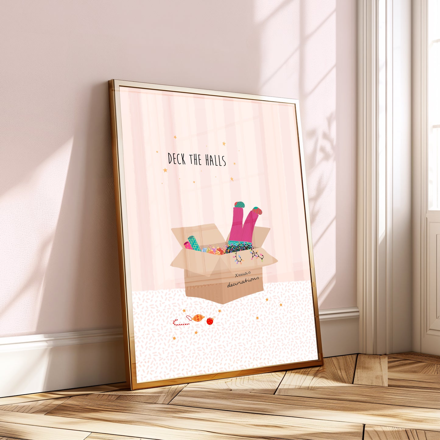 A pink striped illustration with a box of Christmas decorations and colourful lights and a girls legs in pink trousers and mismatched socks dangling out of the top