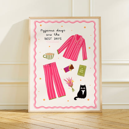 Framed artwork with pink pyjama set, tea cup, book, chocolate and cat illustration on a white background.