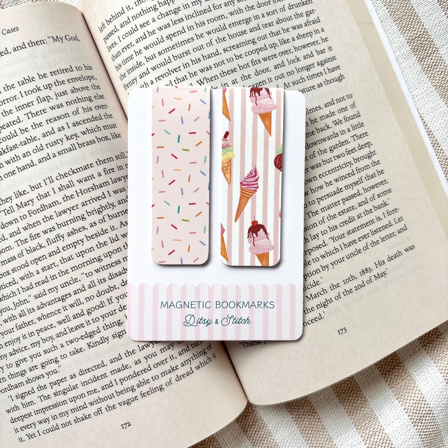 Magnetic bookmarks with ice cream and sprinkles designs on an open book with a striped fabric background