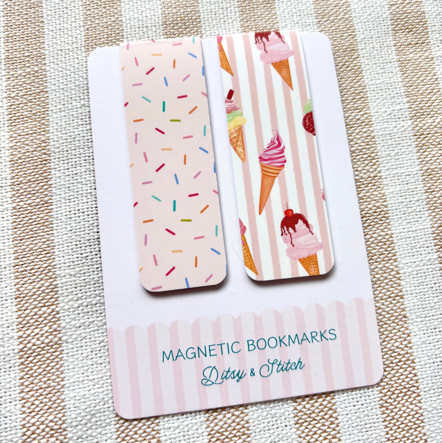 Two magnetic bookmarks with ice cream cone and sprinkles designs on a striped fabric background