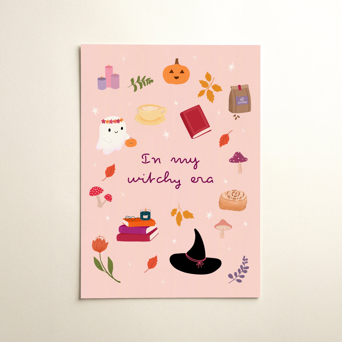 A vertical art print with a light pink background featuring a whimsical autumn and witchy Halloween illustration. The design includes a cute ghost, a jack-o'-lantern, autumn leaves, mushrooms, candles, books, a witch's hat, and the text 'In my witchy era' in purple script.