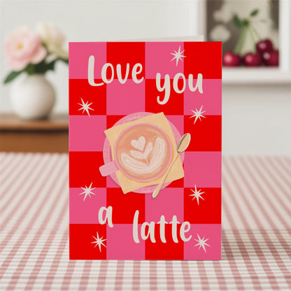 Card with a coffee design and 'Love you a latte' text on a red and pink checkered background.