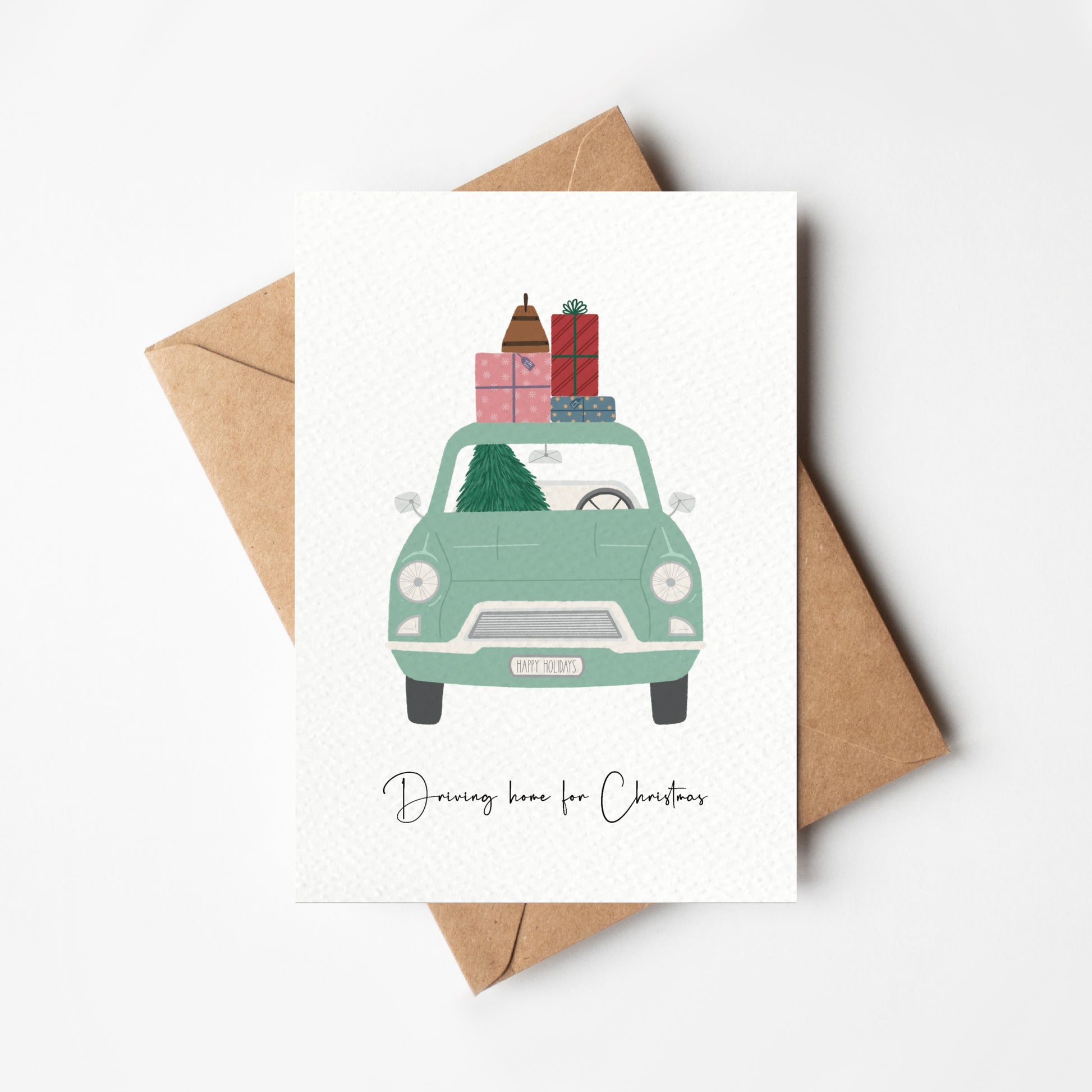 Card with a green car carrying Christmas presents and an envelope on a white background