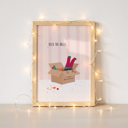 A pink striped illustration with a box of Christmas decorations and colourful lights and a girls legs in pink trousers and mismatched socks dangling out of the top