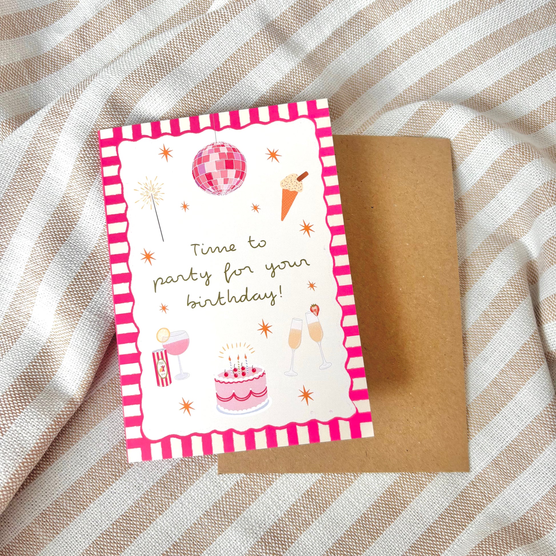 Birthday card with pink and white striped border and party illustrations on a textured fabric background