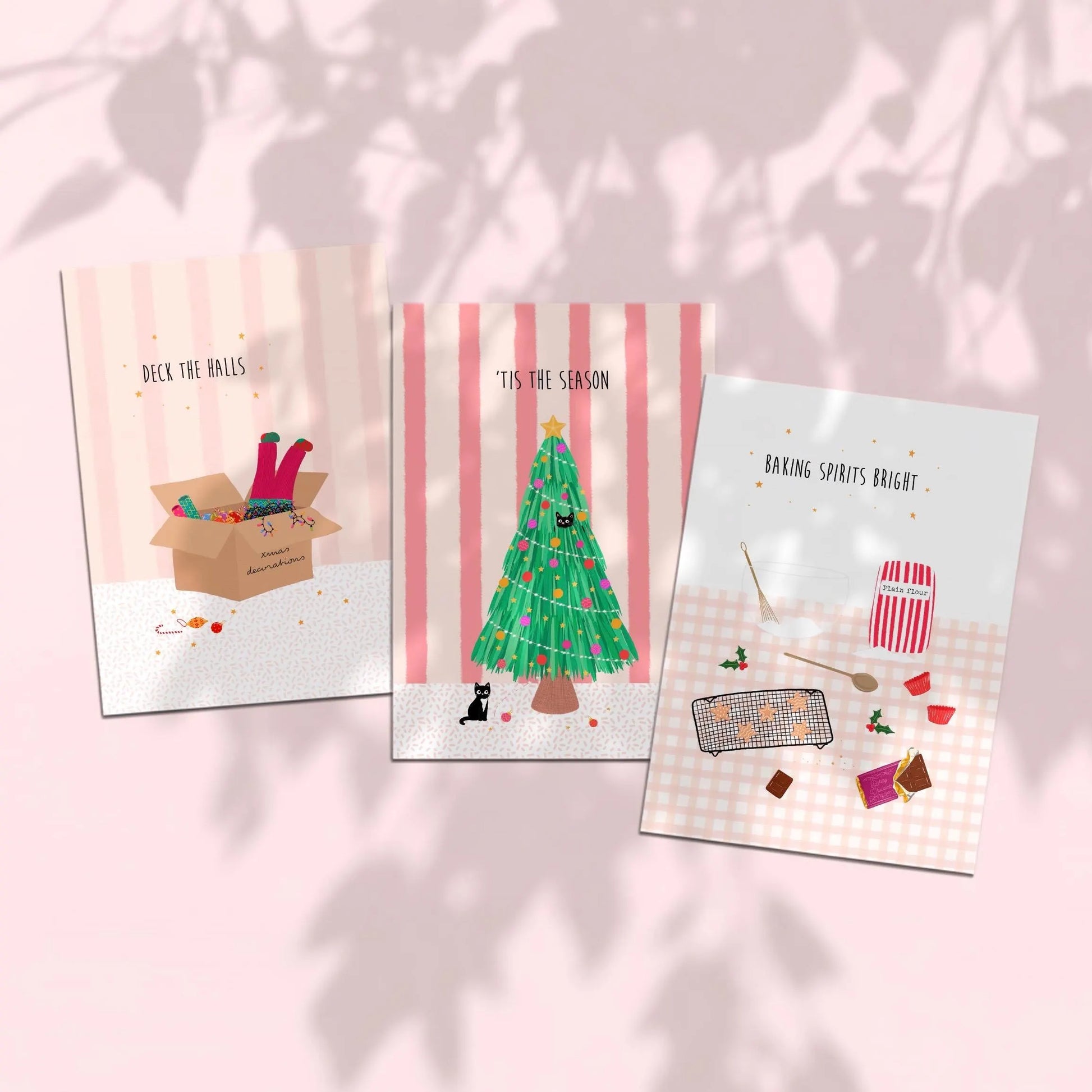 Three pink stripe and gingham patterned Christmas-themed greeting cards on a pink background with leaf shadows.