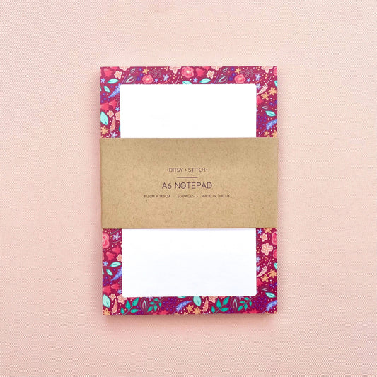 Floral notepad with a brown kraft cover on a pink background