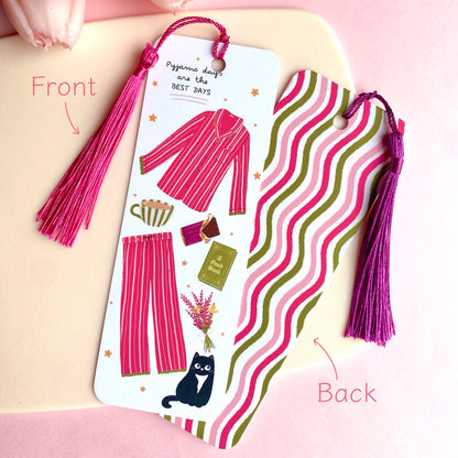 Double-sided pink pyjamas bookmark with pink and purple tassels on a cream background