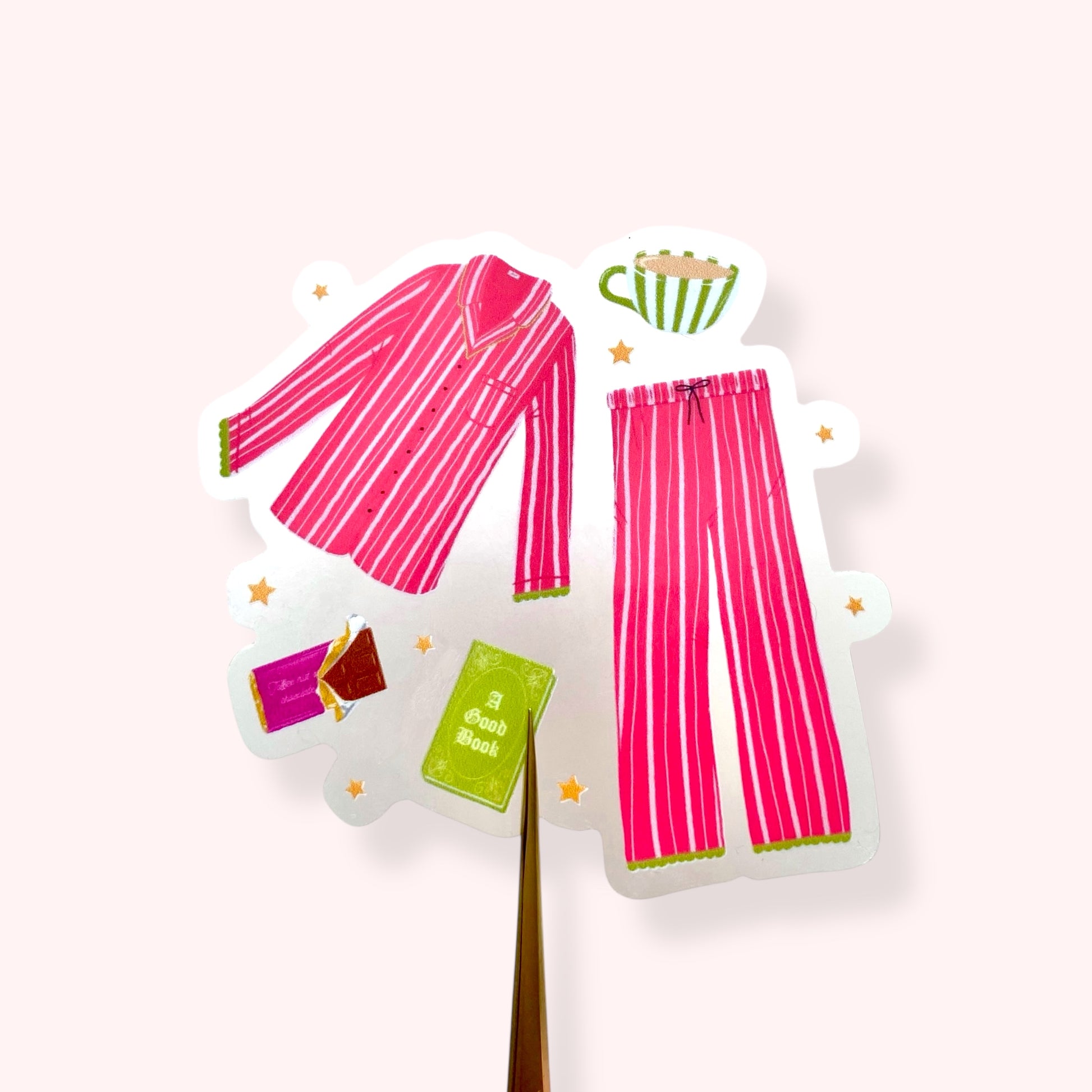 Pink and green striped pyjamas with a book, hot drink mug and chocolate and scattered stars  on a white background