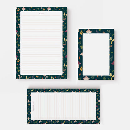 Three autumn notepad sheets with dark teal borders featuring a mushroom and botanical pattern, arranged on a light grey background.