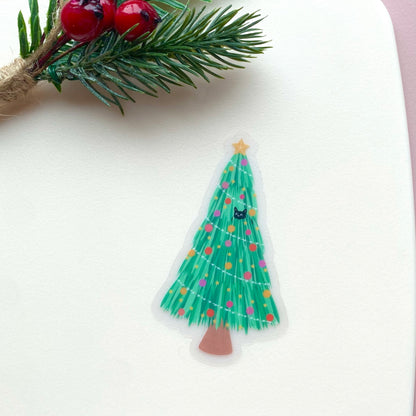 Decorative Christmas tree sticker with colourful ornaments and a star, with 2 black cats playing in and around the tree. On a white background with festive foliage and berries.