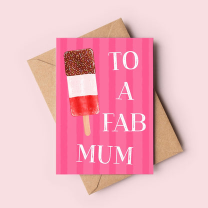 A pink greeting card with vertical stripes and a hand-drawn ice lolly illustration, printed with the words 'TO A FAB MUM' in white. The card is shown with a brown kraft envelope on a light pink background.