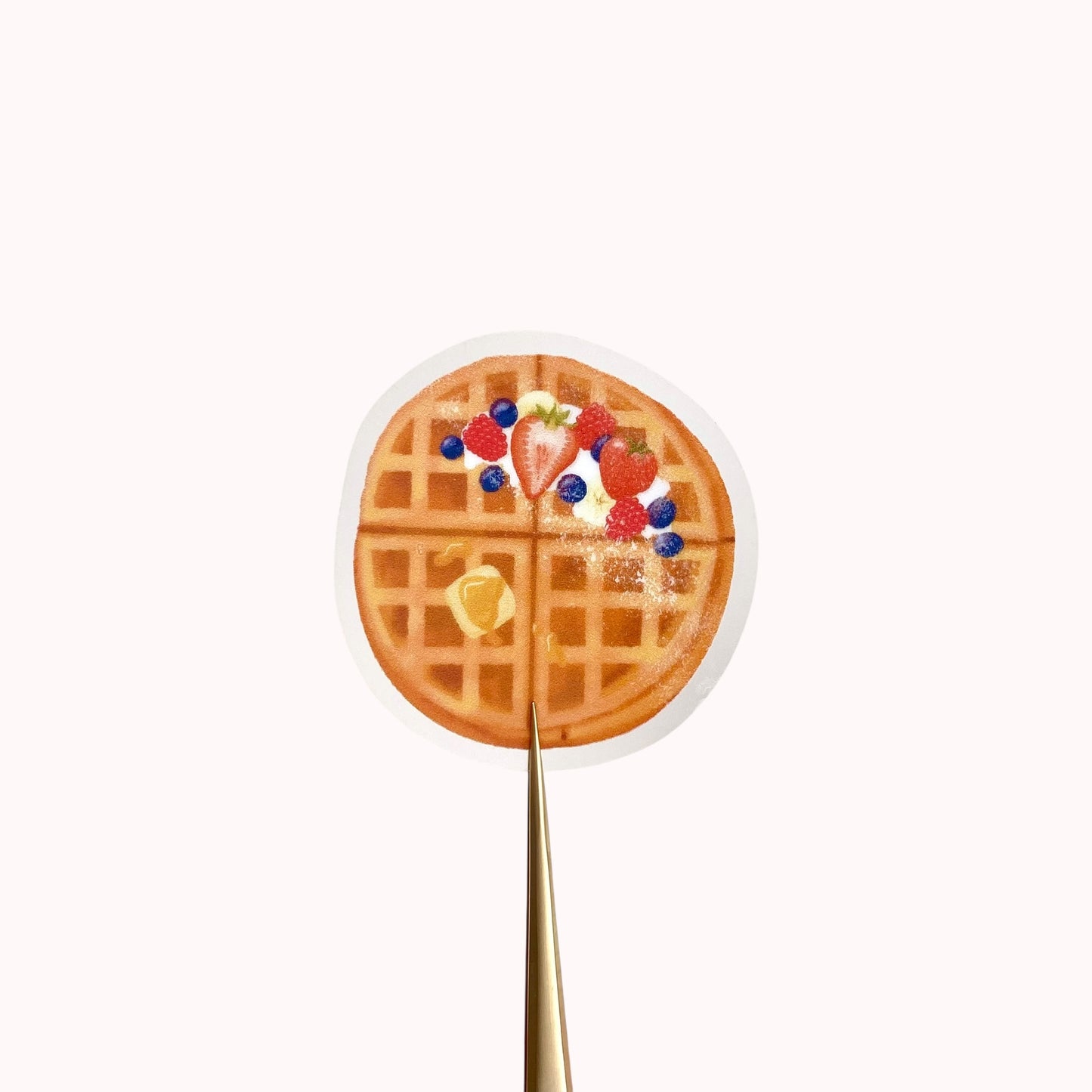 A transparent sticker with a detailed illustration of some breakfast waffles with syrup, butter and mixed summer berries