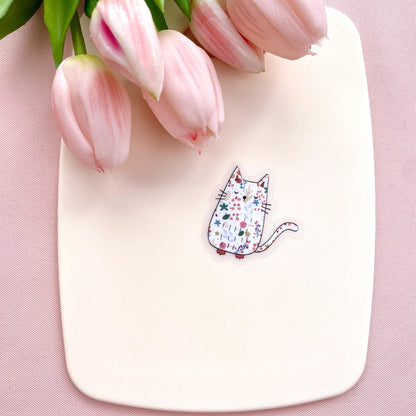 White board with a cat illustration sticker and pink tulips on a pink background