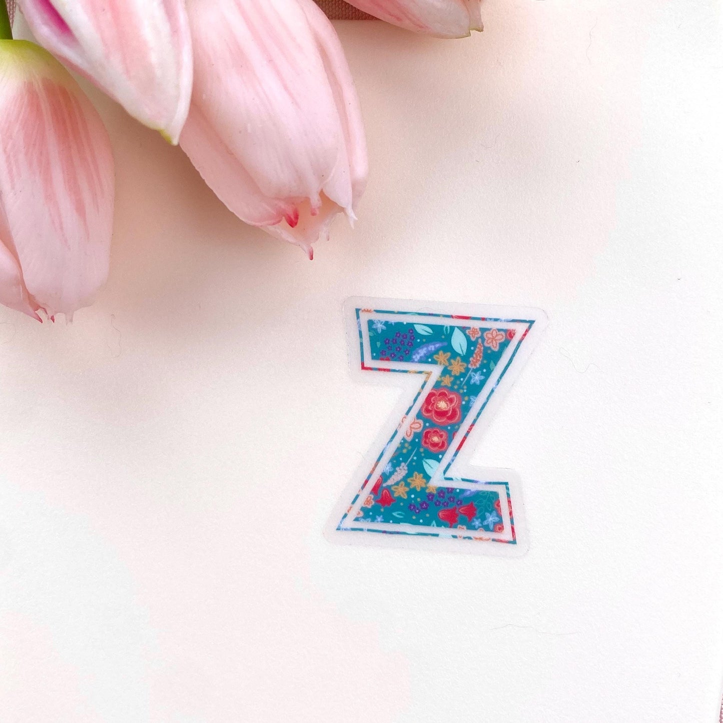 Floral letter 'Z' sticker on a light pink background with pink tulips