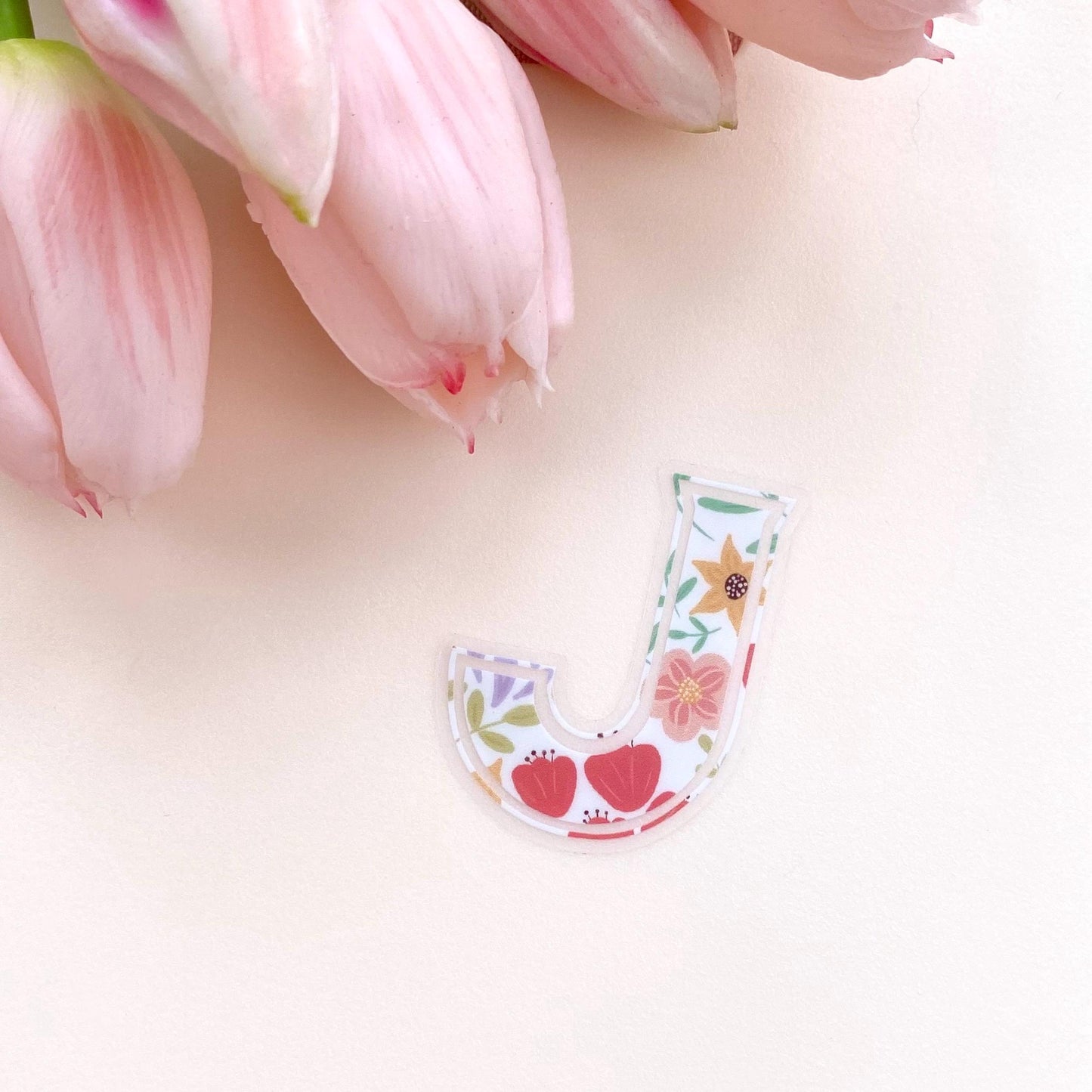Floral letter 'J' sticker with pink tulips on a light background