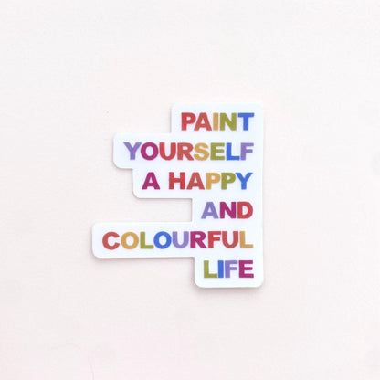 A clear sticker with motivational quote 'Paint yourself a happy and colourful life' on a white background