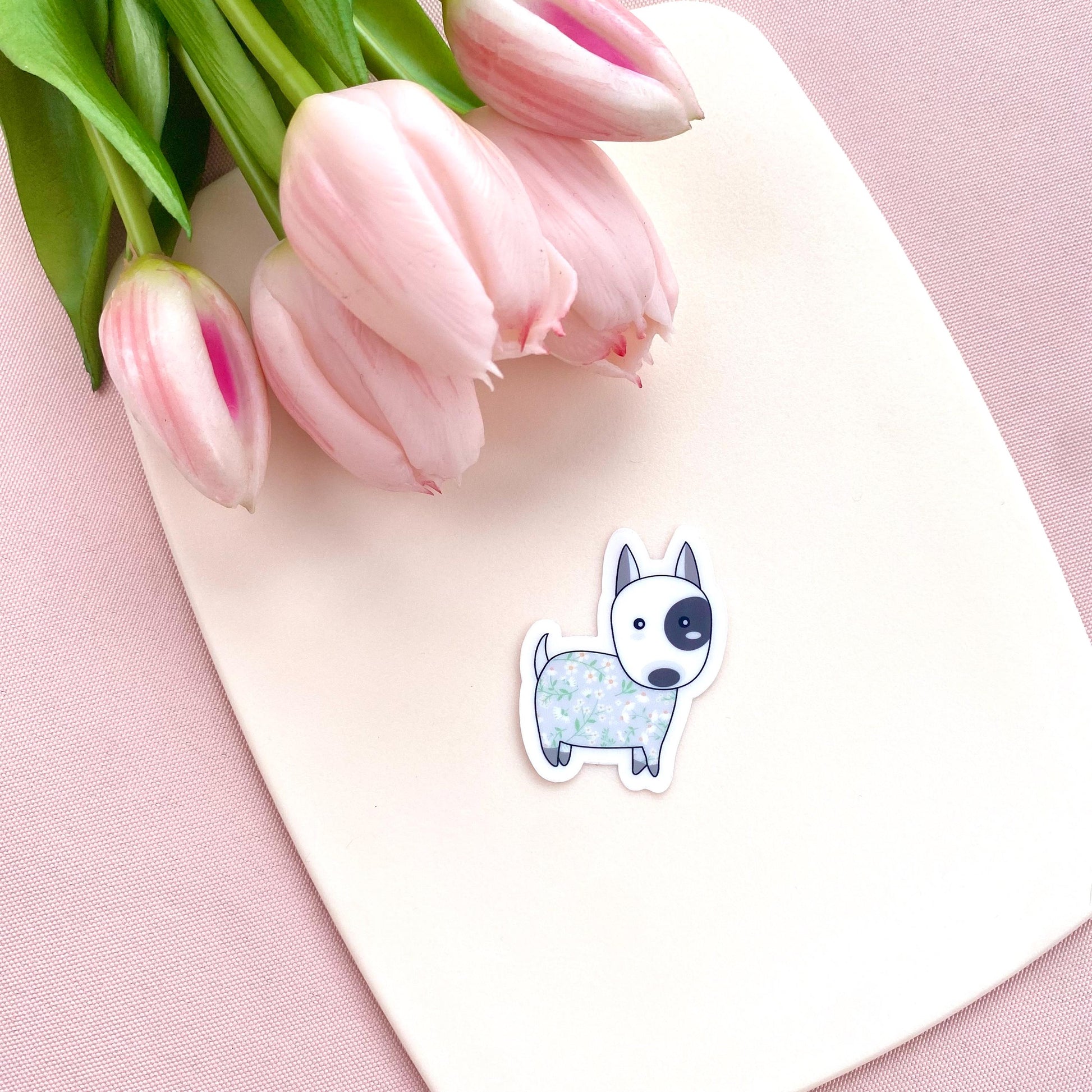 Sticker of a dog with pink tulips on a pink background