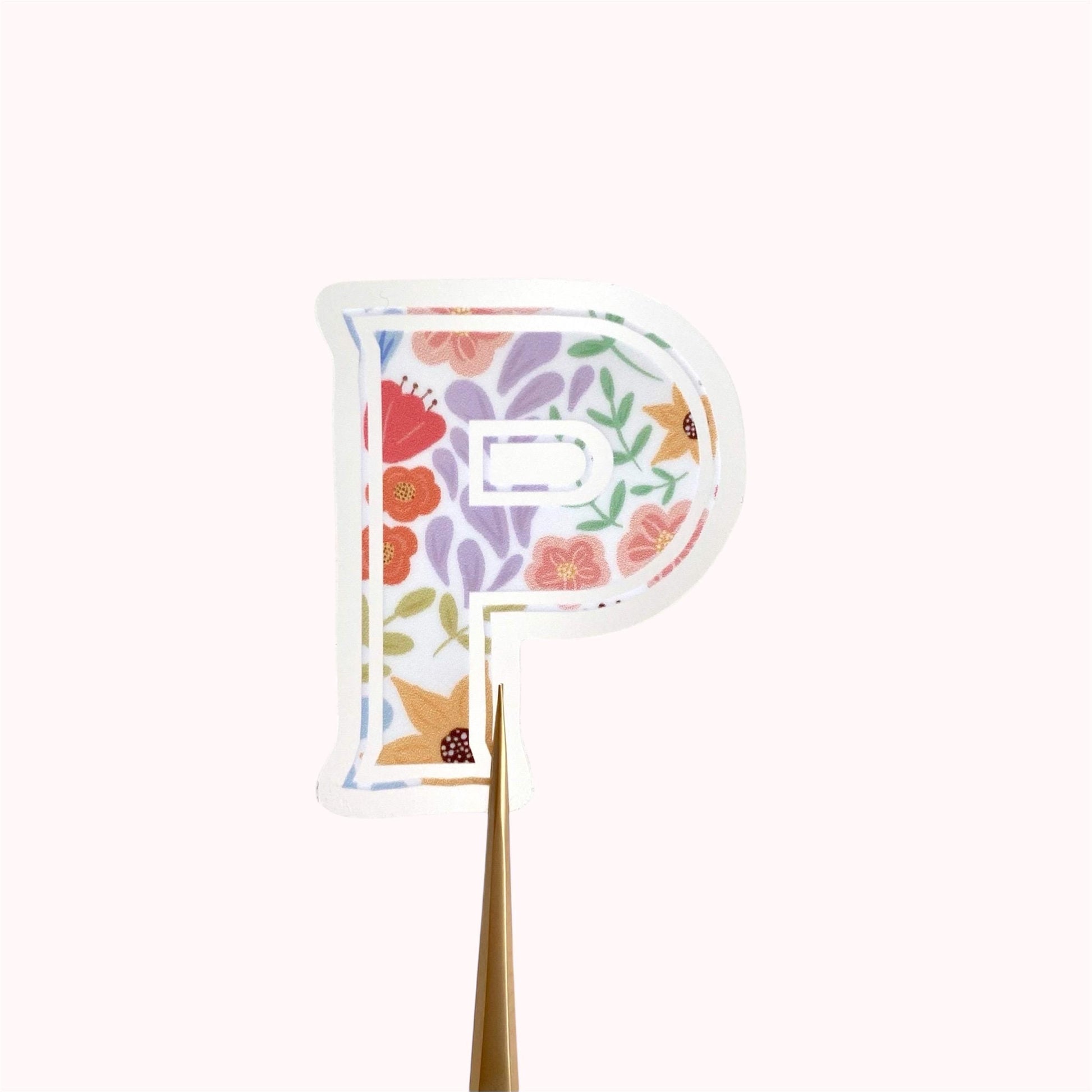 Floral letter 'P' sticker on a cream background.