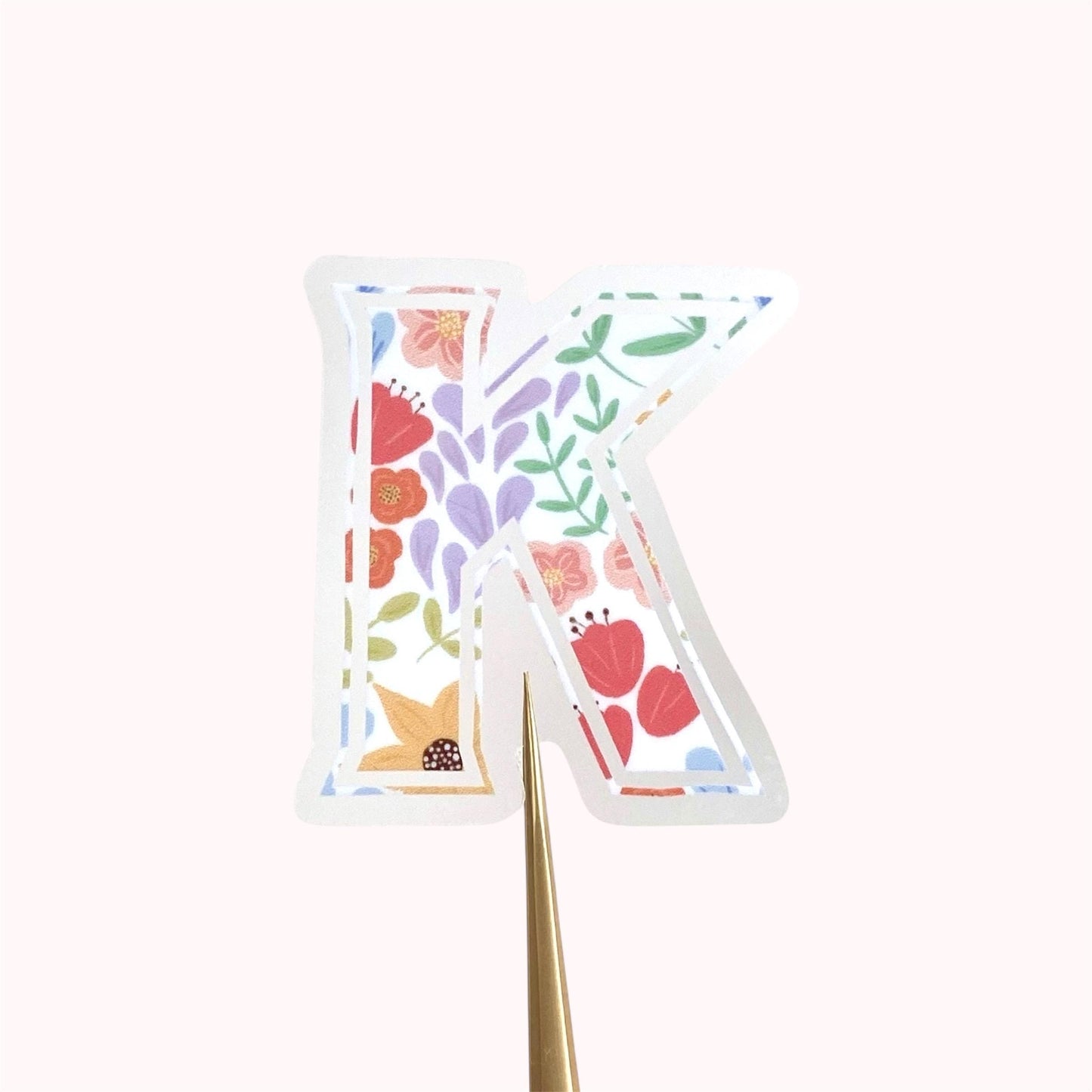 Decorative letter 'K' sticker with floral designs on a white background