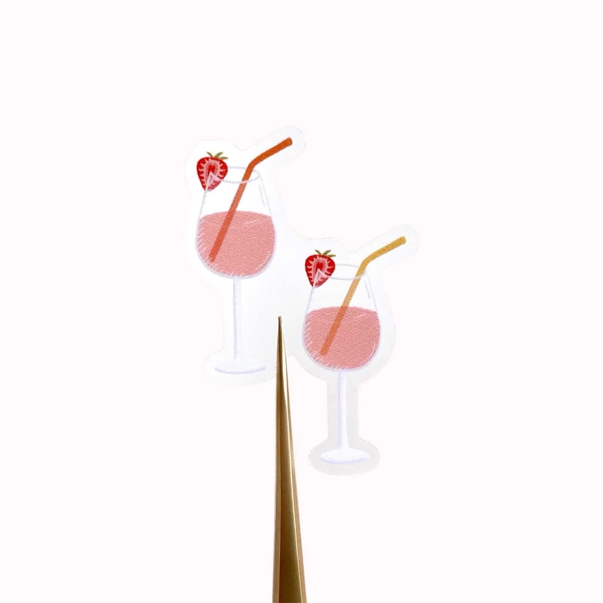 Two pink drinks with strawberry slices and straws on a white background