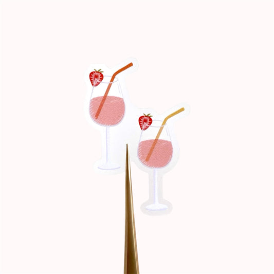 Two pink drinks with strawberry slices and straws on a white background