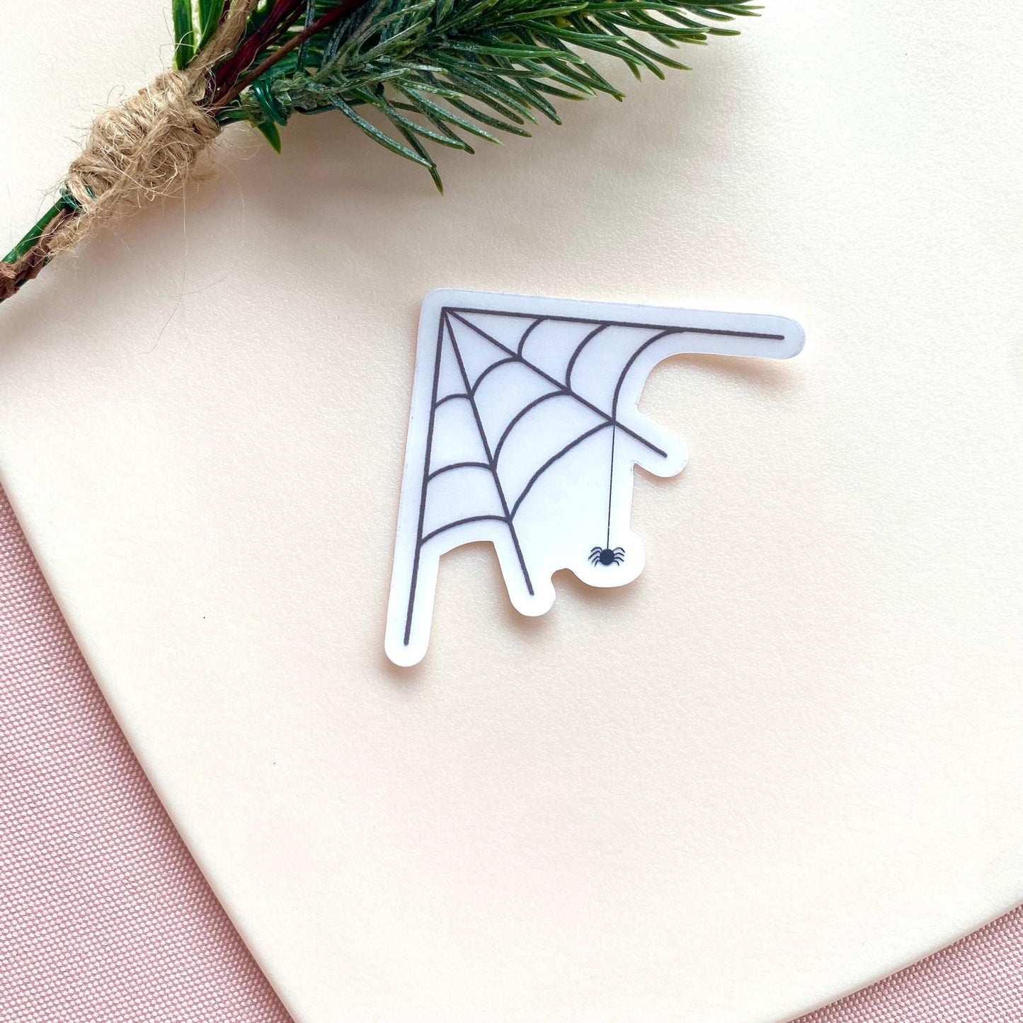 Transparent sticker with corner spider web design with a hanging spider on a white background