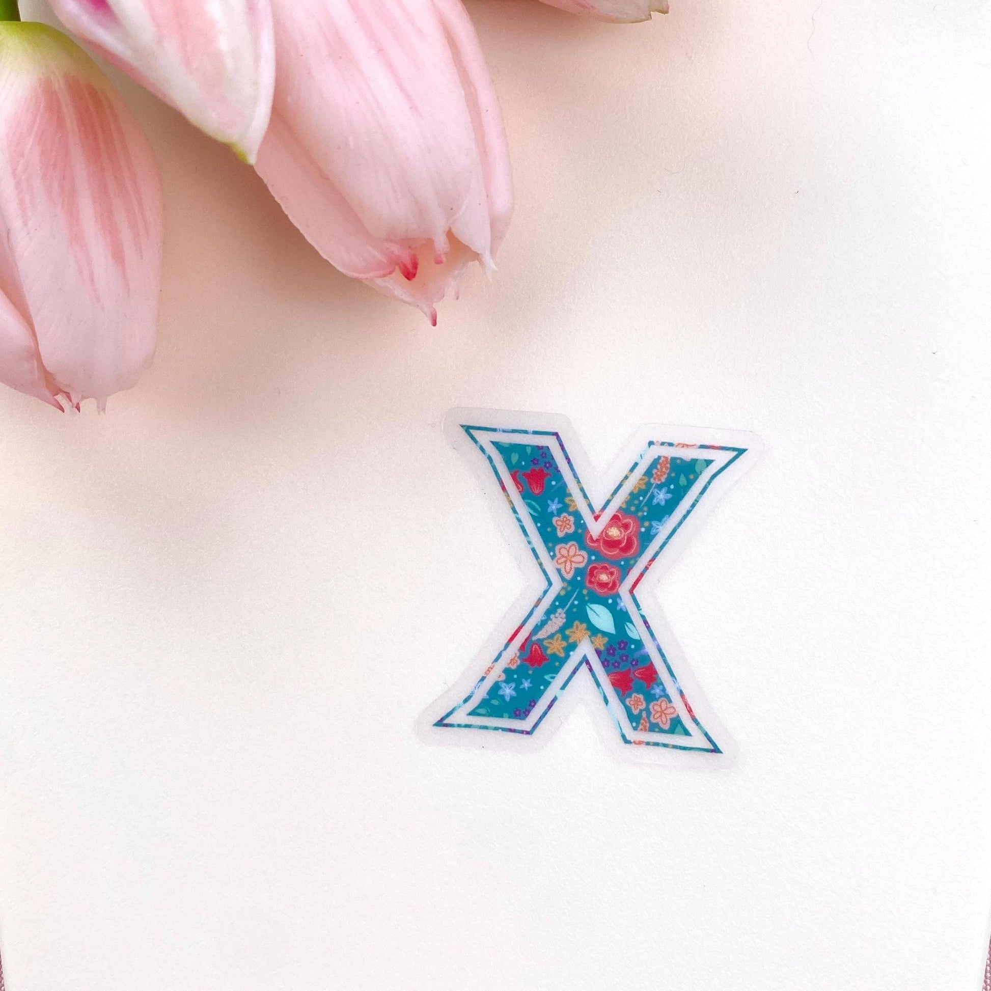 Floral letter 'X' sticker on a light background with pink tulips