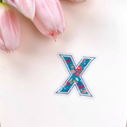 Floral letter 'X' sticker on a light background with pink tulips