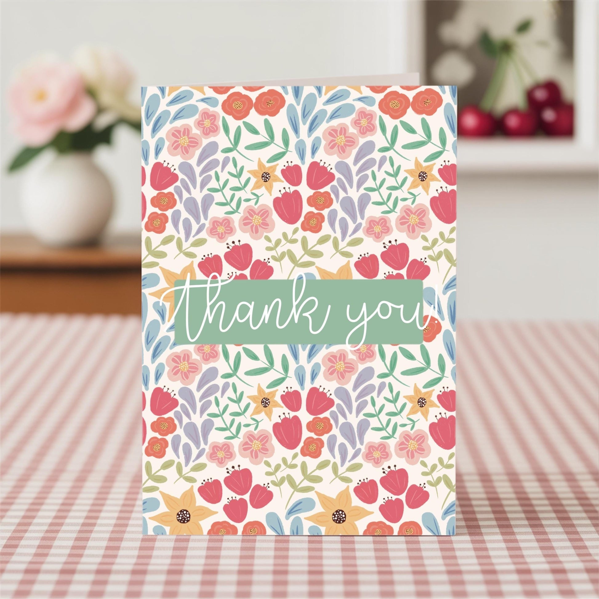 Floral card with 'thank you' text on a checkered tablecloth
