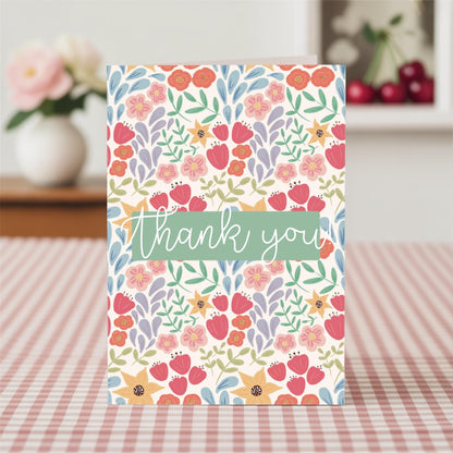 Floral card with 'thank you' text on a checkered tablecloth