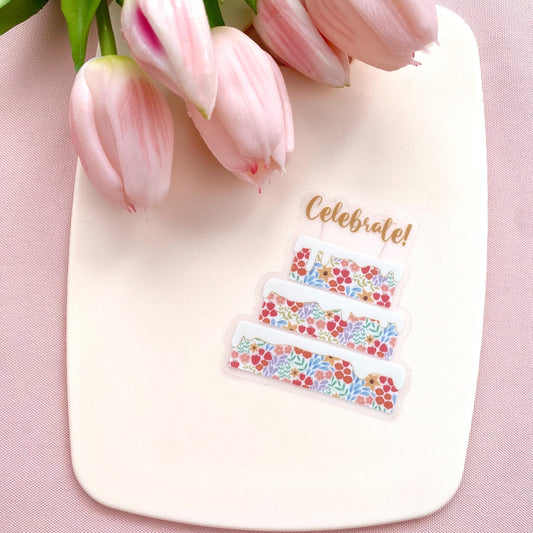 Decorative sticker with floral designs and 'Celebrate!' text on a pink background with tulips.