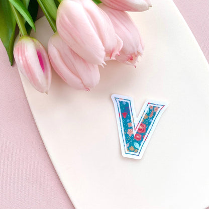 Decorative letter 'V' sticker with floral design on a white background with pink tulips