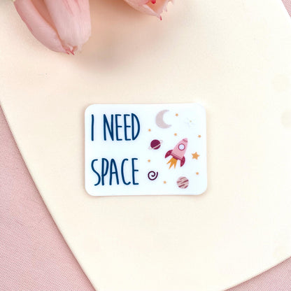 Transparent sticker with 'I NEED SPACE' text and space illustrations against a white background with pink tulips.