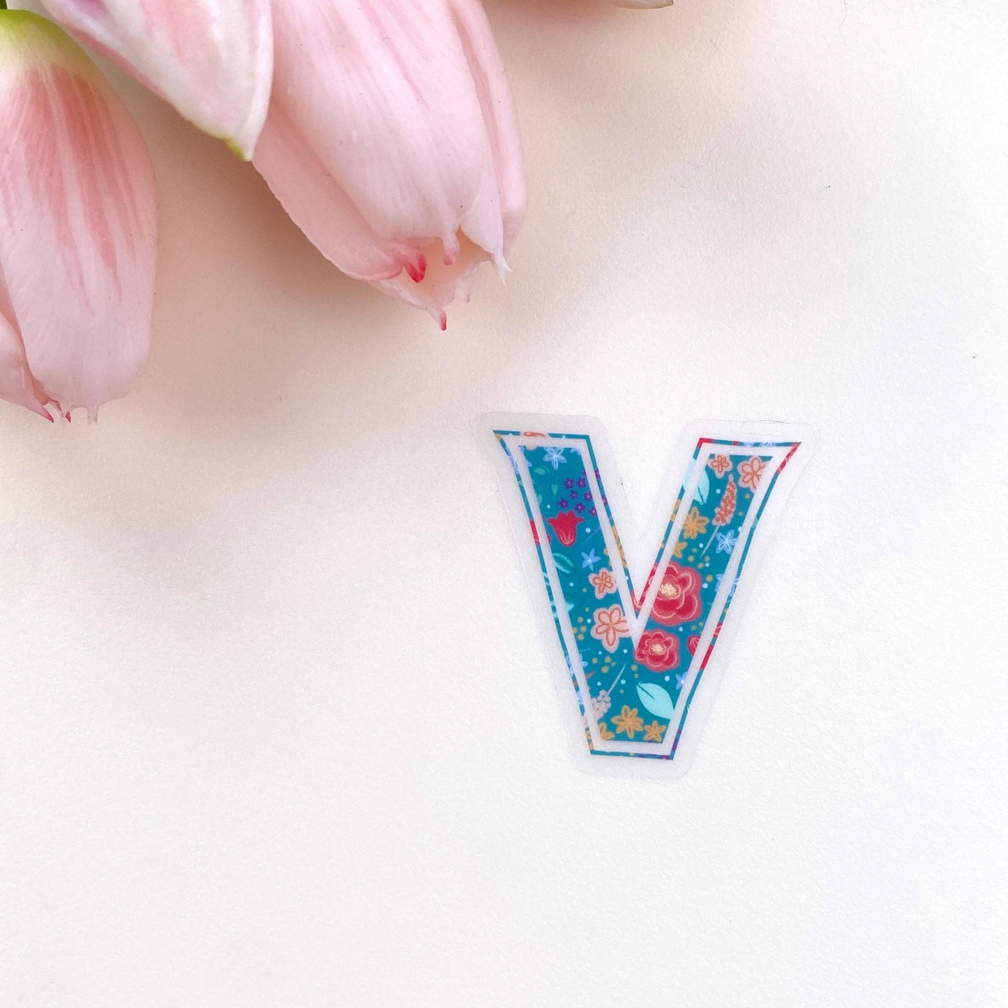 Floral letter 'V' sticker on a white background with pink tulips