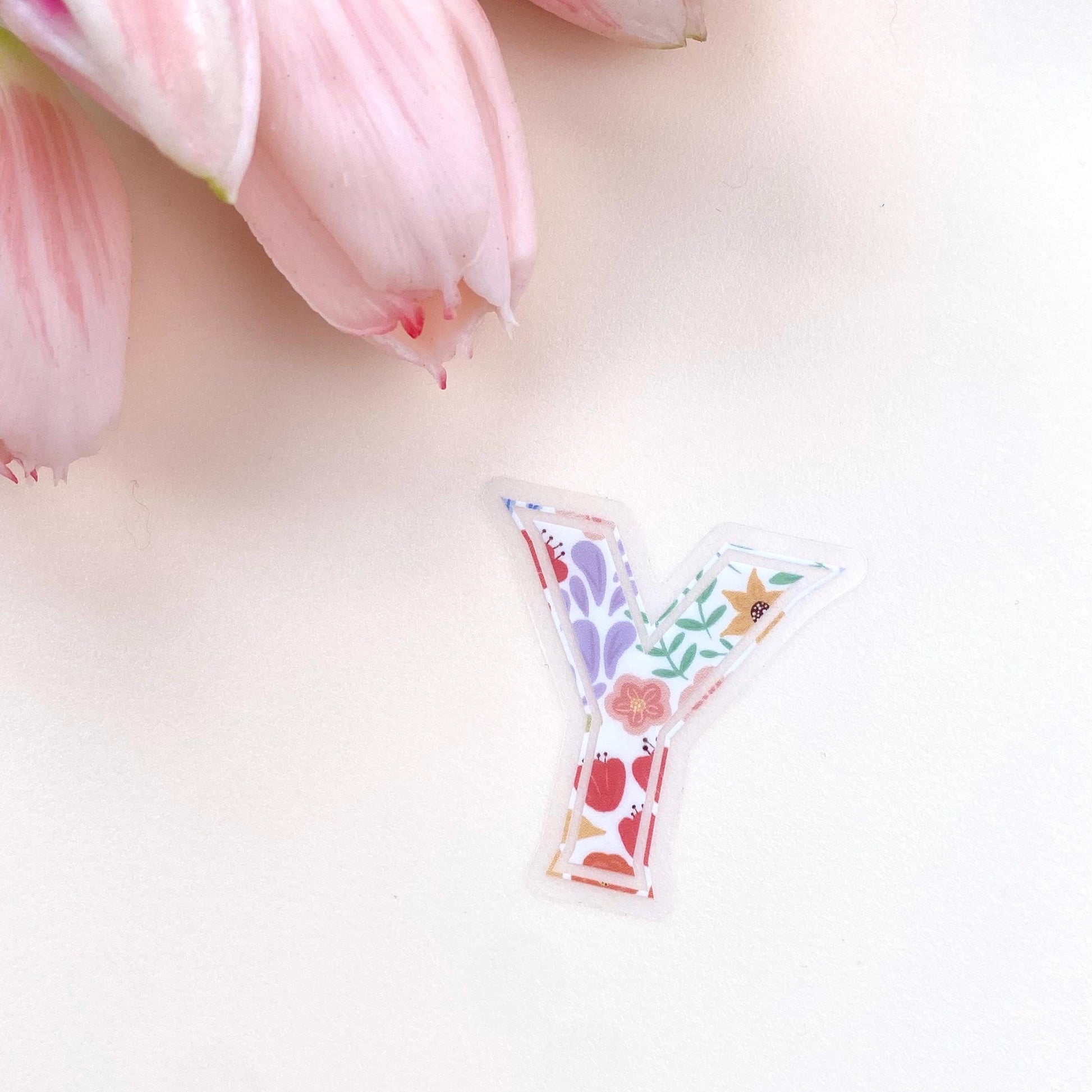 Decorative letter 'Y' sticker with floral design on a light pink background with tulips.