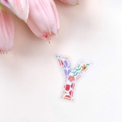 Decorative letter 'Y' sticker with floral design on a light pink background with tulips.