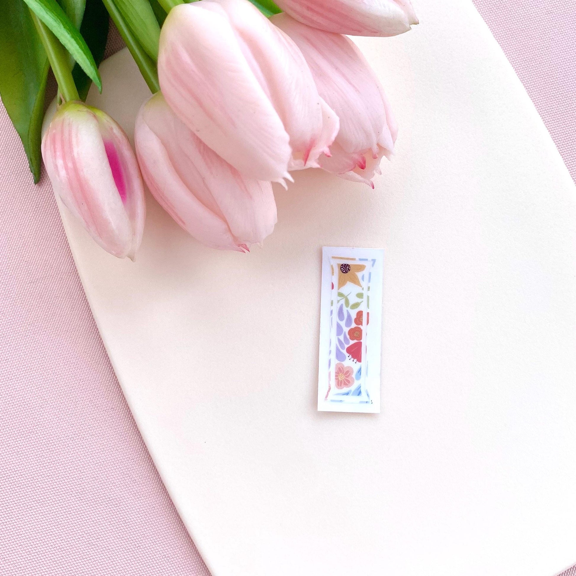A floral-patterned letter 'I' sticker against a white background with pink tulips.