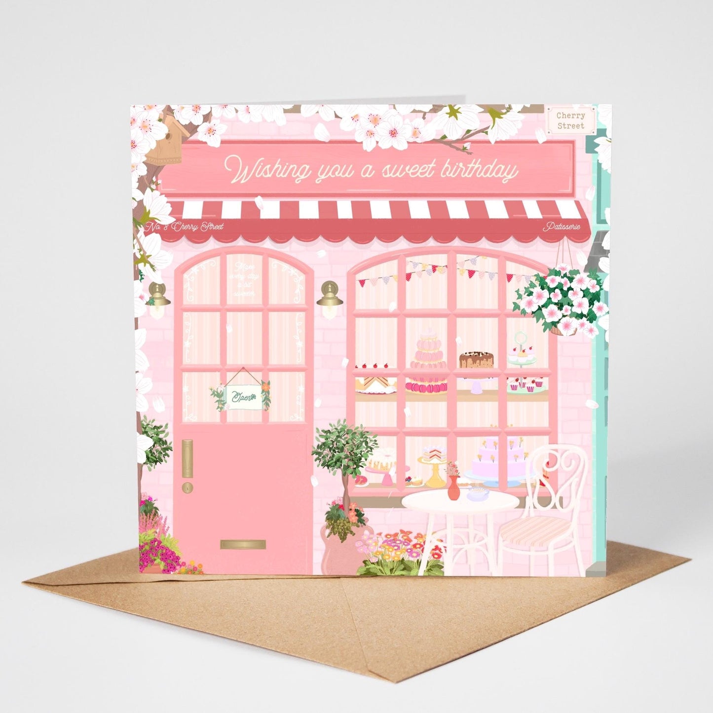 Card with a pink bakery illustration and 'Wishing you a sweet birthday' text on a brown envelope.