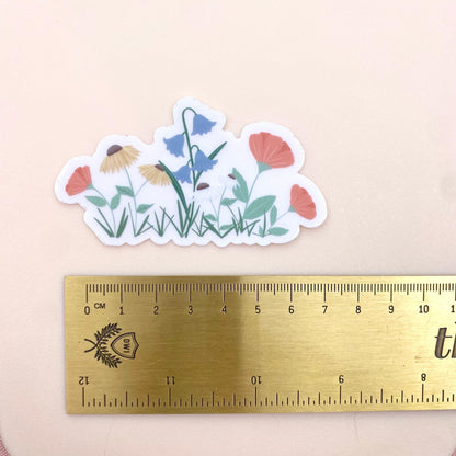 Floral sticker with a ruler for scale on a beige background