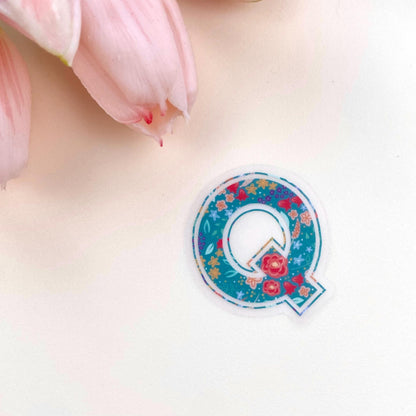 Decorative letter 'Q' sticker with floral design on a white background