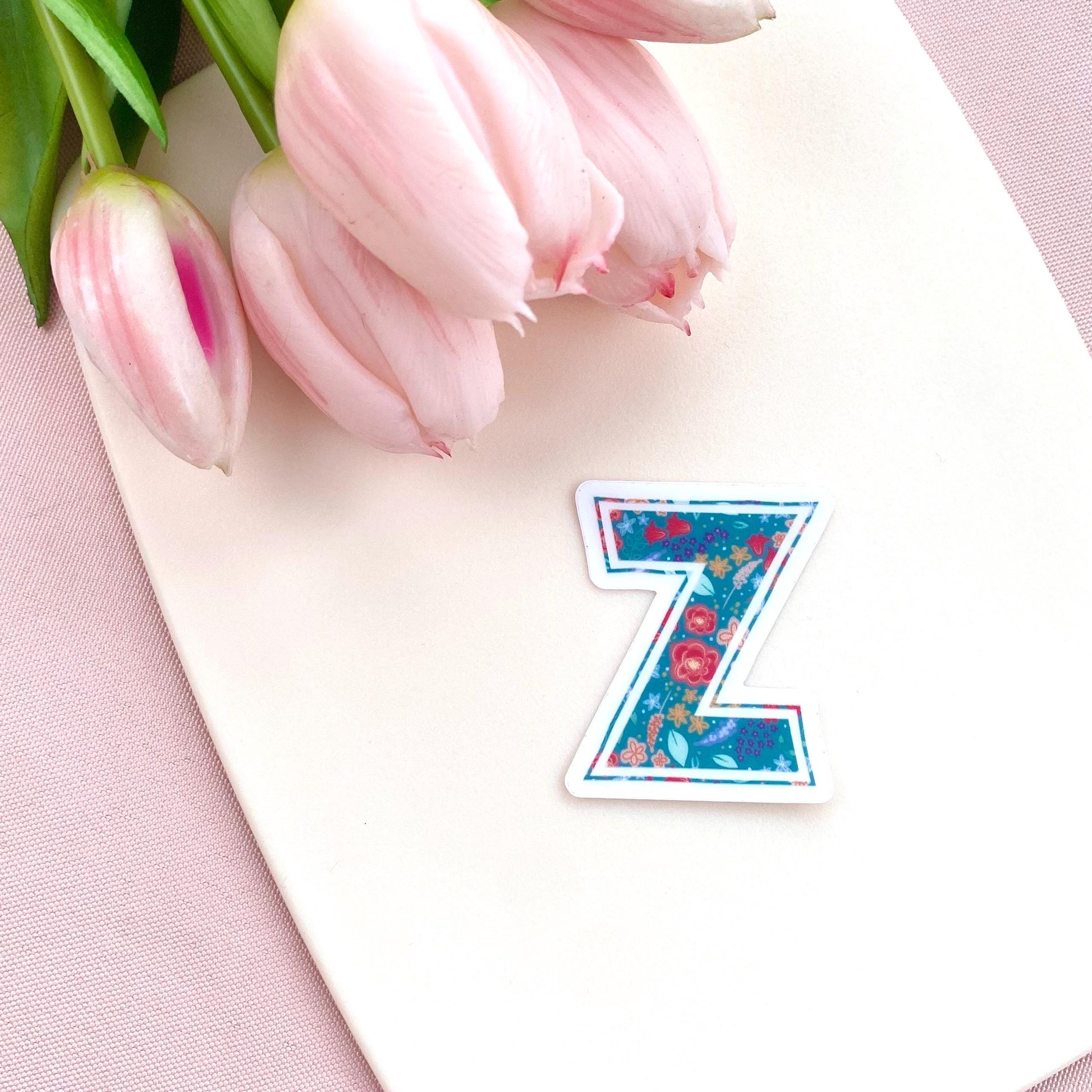 Floral letter 'Z' sticker on a pink surface with tulips