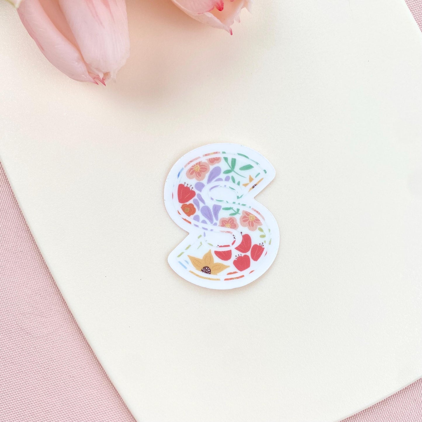 Decorative letter 'S' sticker with floral pattern on a white background