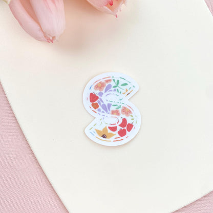 Decorative letter 'S' sticker with floral pattern on a white background