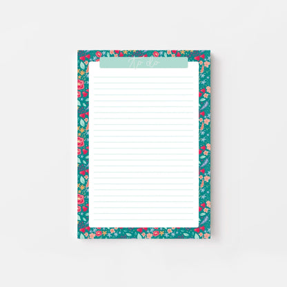 Floral-patterned notepad with a white writing surface on a light gray background