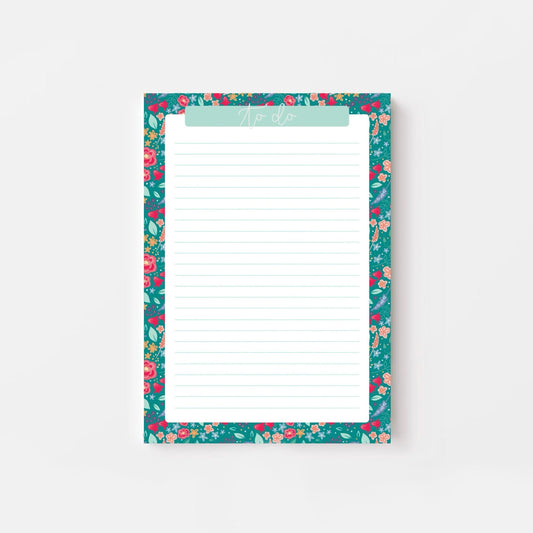 Floral-patterned notepad with a white writing surface on a light gray background