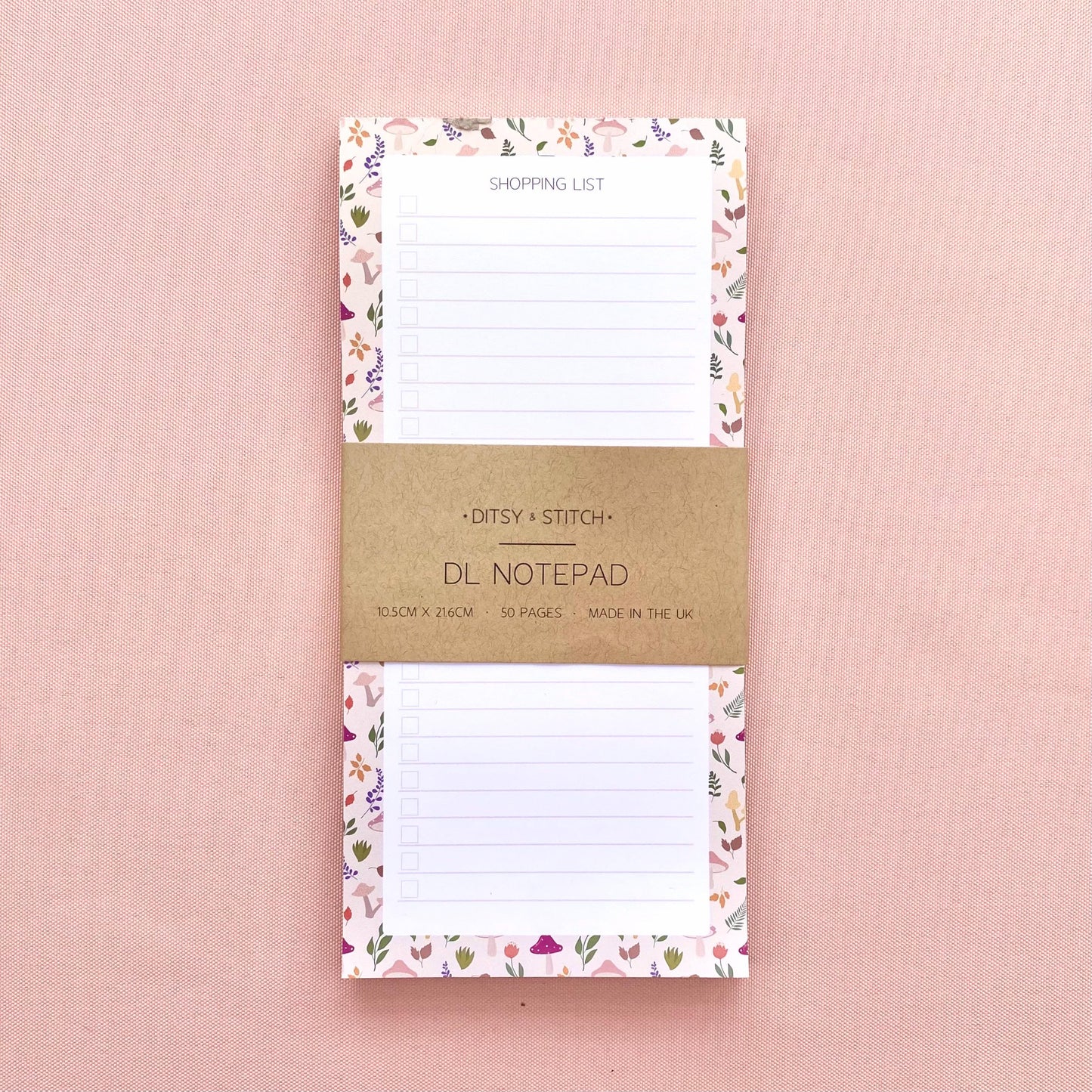 Autumn foliage-patterned shopping list notepad on a pink background
