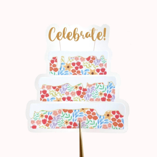 Decorative cake sticker with floral pattern and gold 'Celebrate!' text on a white background
